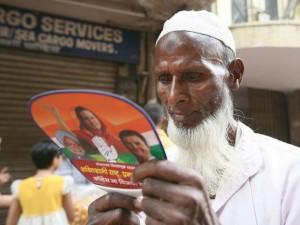 Un votante indio lee una propaganda política durante un acto del derrotado Partido del Congreso, en Mumbai. Crédito: Al Jazeera