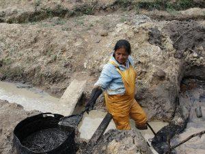 La quichua Rosa Tanguila limpia la contaminación petrolera que dejó Texaco en un arroyo de su comunidad, Rumipamba, en la Amazonia ecuatoriana. Crédito: Gonzalo Ortiz/IPS