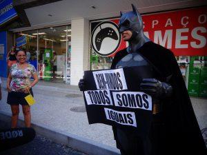 El personaje de Batman, habitual en las manifestaciones de Río de Janeiro, apoya a los “rolezinhos” frente al Shopping Leblon, con un cartel que dice “todos somos iguales”. Crédito: Fabiana Frayssinet/IPS