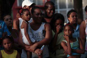 Una mujer cubana sostiene a su hija en brazos mientras disfrutan de un espectáculo de teatro callejero enun barrio de La habana. Crédito: Jorge Luis Baños/IPS