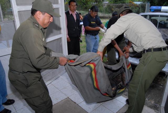 Dos policías transportan el cuerpo quemado de una víctima de linchamiento en una comunidad de Chapare, en el departamento boliviano de Cochabamba. Crédito: Dico Soliz /Opinión