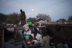 Un bote con mujeres y niños llega a Mingkaman, en el condado de Awerial. En menos de un mes, cerca de 84.000 personas cruzaron el Nilo huyendo de los combates. Crédito: Mackenzie Knowles-Coursin/IPS