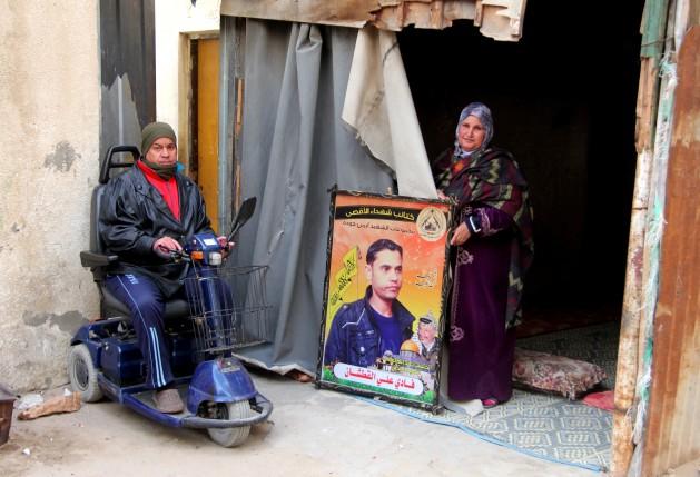 El padre y la madre de Fadi al Qutshan muestran su fotografía en su casa de Gaza. Crédito: Khaled Alashqar/IPS