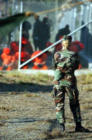 Una soldado observa a prisioneros de Guantánamo el 11 de enero de 2002. Crédito: Dominio público