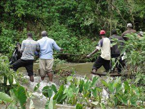 Un grupo de agricultores construye una barrera para proteger sus cultivos del río Nduyi, que suele desbordarse cuando se produce un aguacero fuerte. Crédito: Miriam Gathigah/IPS