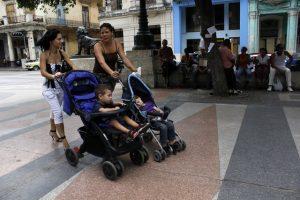 Dos jóvenes madres cubanas pasean con sus hijos por una avenida de La Habana. Crédito: Jorge Luis Baños/IPS