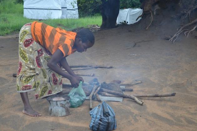 Agnes Katete enciende un fuego al lado de su tienda. Ella es una de las tantas personas afectadas por las inundaciones de marzo. Crédito: Mabvuto Banda/IPS