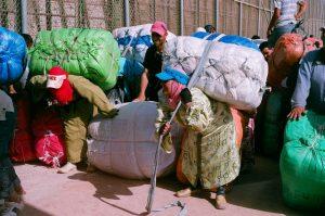 Porteadoras marroquíes esperan, cargadas con grandes fardos, en el paso del Barrio Chino, en la ciudad autónoma española de Melilla, en el norte de África. Crédito: Cortesía de José Palazón/Asociación Pro Derechos Humanos de la Infancia