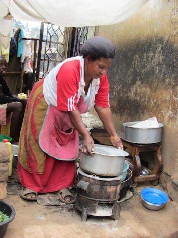 Una mujer en el tugurio ugandés de Katwe usa una cocina mejorada y eficiente para reducir el uso de carbón. Estos artefactos se distribuyen en Uganda como parte de proyectos para la reducción de emisiones. Crédito: Wambi Michael/IPS.