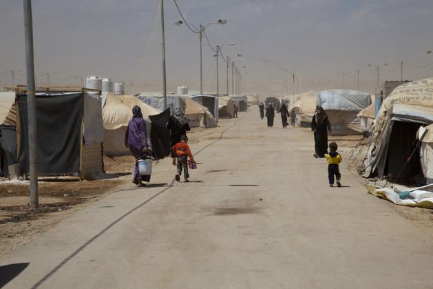 Esta calle, que atraviesa el campamento de refugiados de Zaatari, en Jordania, fue nombrada Campos Elíseos. Hombres árabes se acercan para comprar vírgenes. Crédito: Liny Mutsaers/IPS.